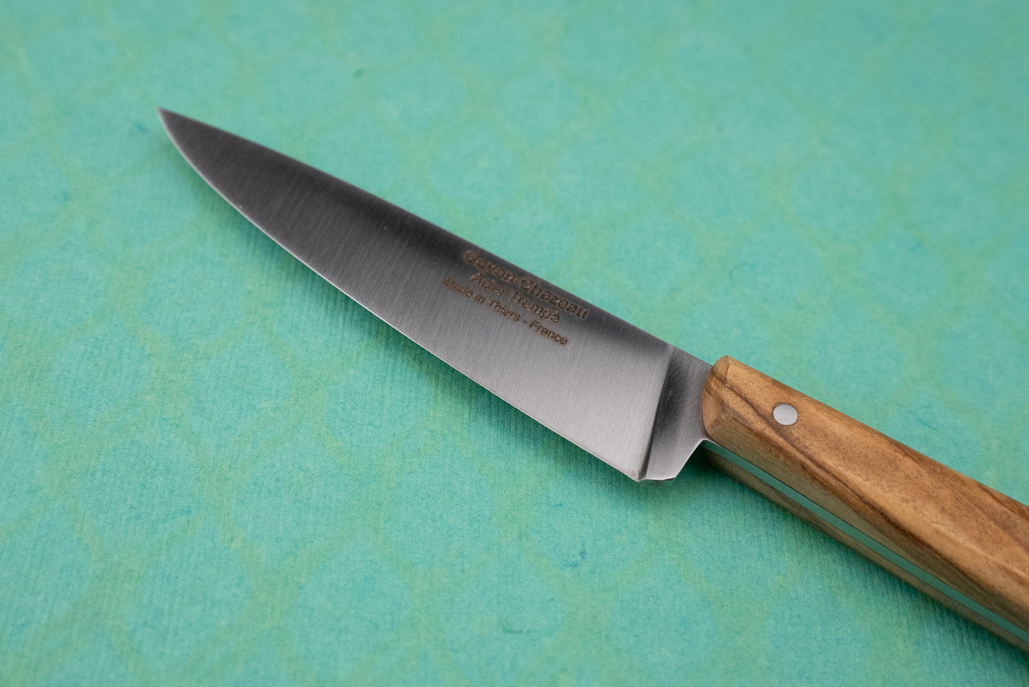 Goyon-Chazeau Le P'tit Tradi knife features a stainless steel blade and wooden handle, ideal for precise tasks like slicing shallots and herbs, embodying craftsmanship in a compact design.