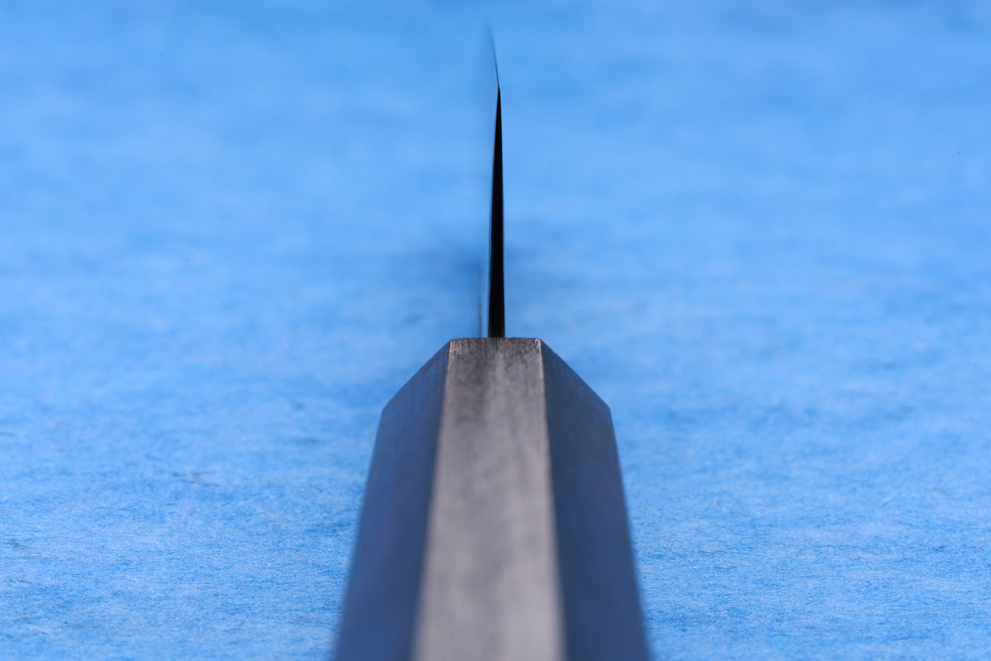Hatsukokoro SLD Hikari Kurozome Damascus Santoku 170mm, viewed end-on, showcasing its precise, sharp edge and elegant steel shank, ideal for versatile kitchen tasks.