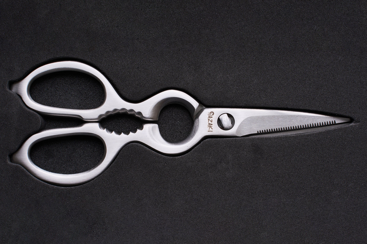 Hazaki Stainless Kitchen Shears, featuring polished stainless steel with ergonomic looped handles, a serrated blade, built-in nutcracker, and bottle opener, ideal for versatile kitchen use.