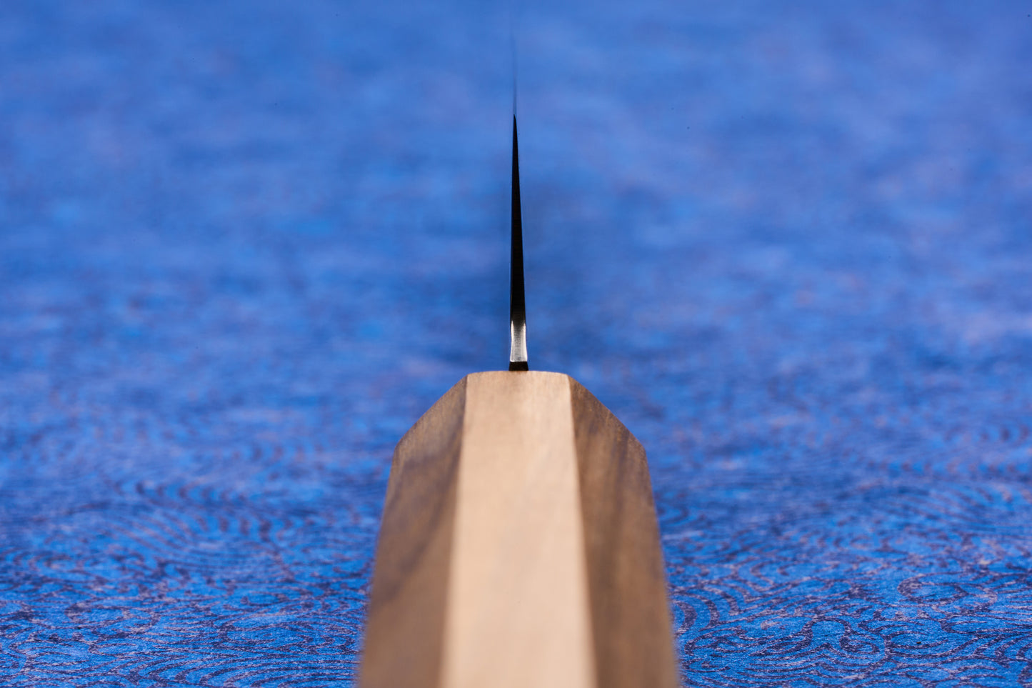 Close-up of the ICHIGO Haku Petty 150mm knife, showcasing its slender, high-performance blade and light wooden 'wa' handle, ideal for precision tasks on a cutting board.