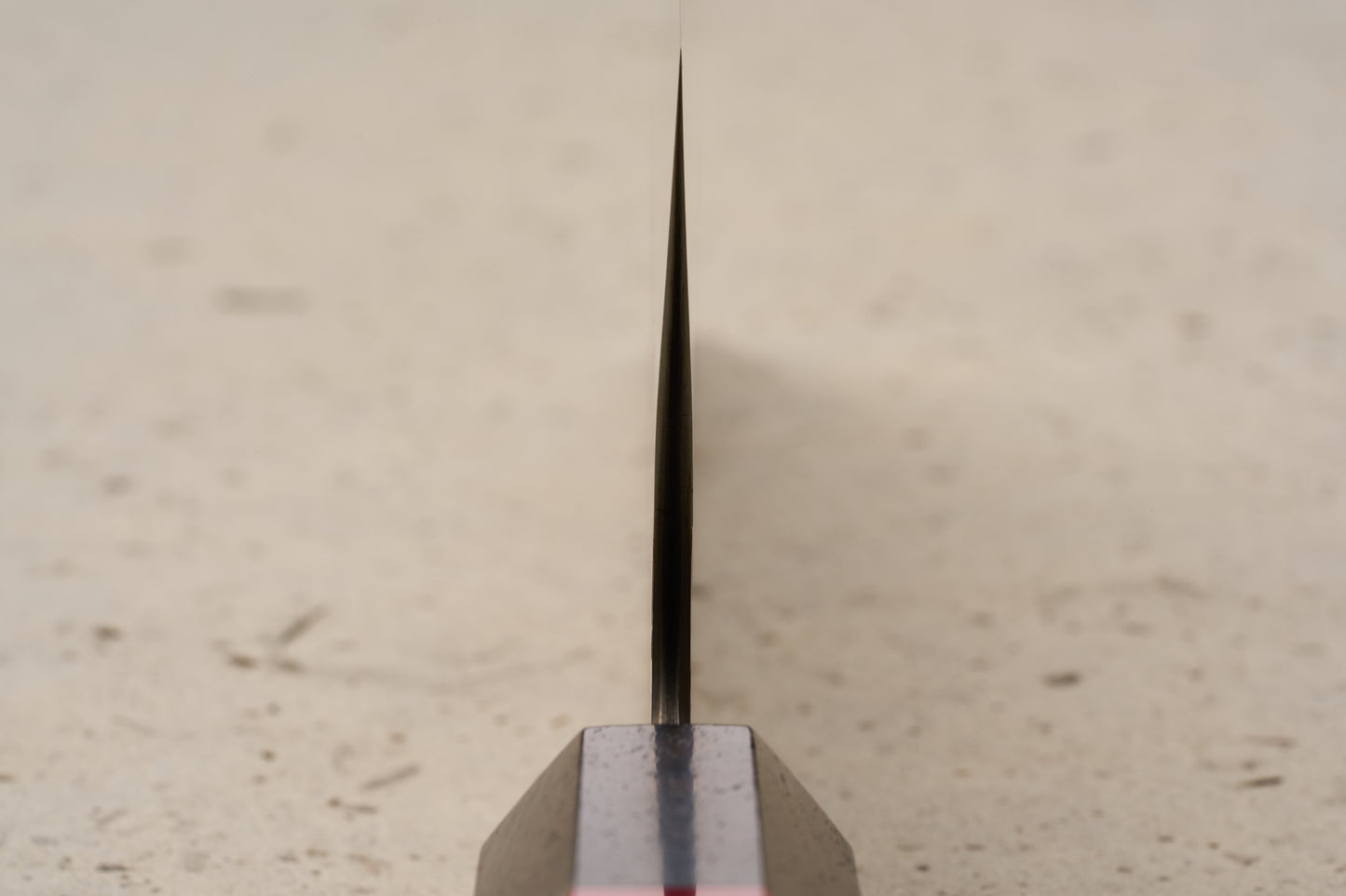ICHIE x Shibata Knives SG2 Tsuchime Nakiri 165mm stands upright on a dark base, showcasing its thin metal blade's spine, designed for precise vegetable chopping, reflecting Japanese craftsmanship from Knifewear.