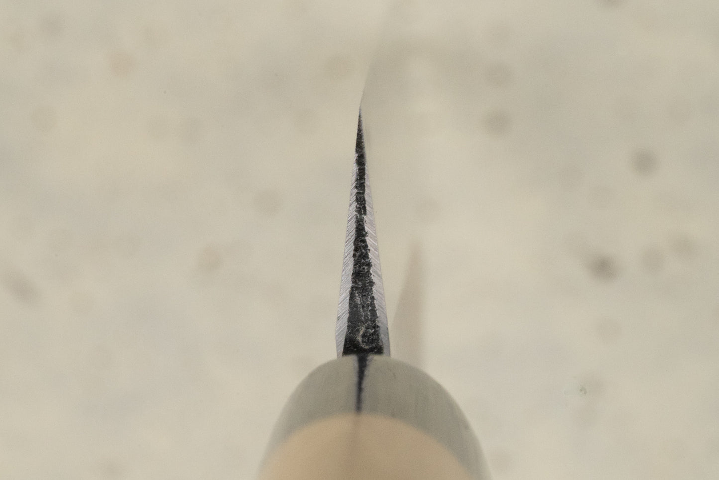 Masamoto KK Shirogami Kasumi Yanagiba 270mm knife, captured edge-on, showcasing its thin, sharp blade with a hint of the rounded handle, epitomizing exquisite Japanese craftsmanship for precision slicing.