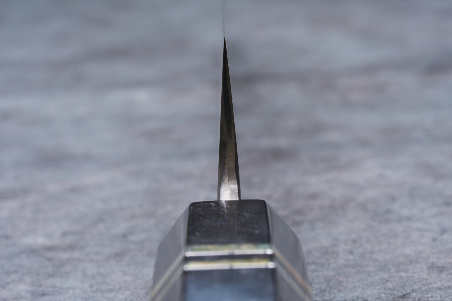Mazaki Aogami Super Honsanmai Damascus Sakimaru Sujihiki 300mm blade clamped in sharpening guide on a whetstone, ready for precision sharpening.