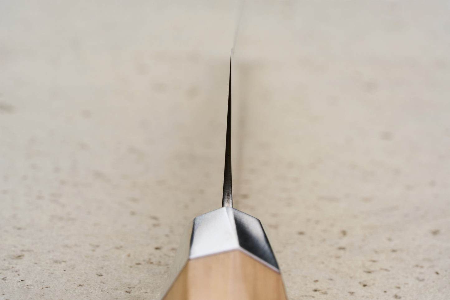 Mcusta Zanmai Beyond Bread Knife 230mm, viewed head-on, showcases its thin, razor-sharp serrated edge and elegant Hinoki wood handle, epitomizing the luxury craftsmanship of Seki City's renowned blade artisans.