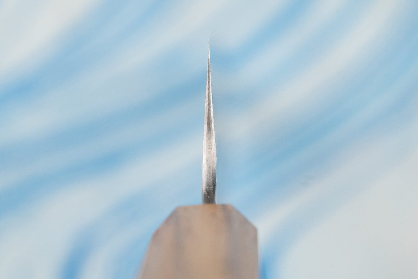 Nigara SPG STRIX Tsuchime Damascus Sujihiki 240mm—close-up of its slender, sharp blade with a wooden handle, showcasing expert craftsmanship ideal for precise slicing of meats and proteins.