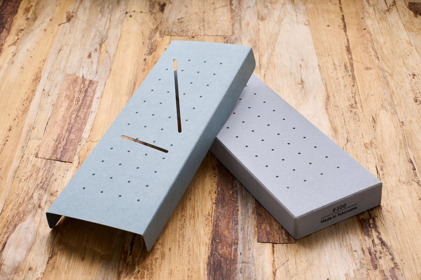 10 Good Coarse 300 Grit Stone with drainage base, ideal for sharpening beginners, displayed on a wooden bench.
