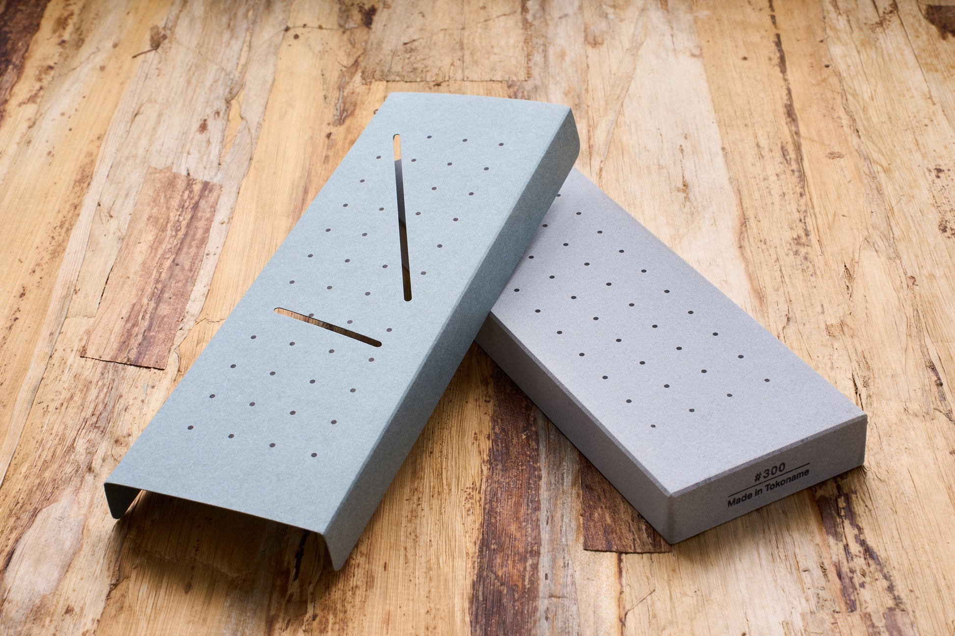 10 Good Coarse 300 Grit Stone with drainage base, ideal for sharpening beginners, displayed on a wooden bench.