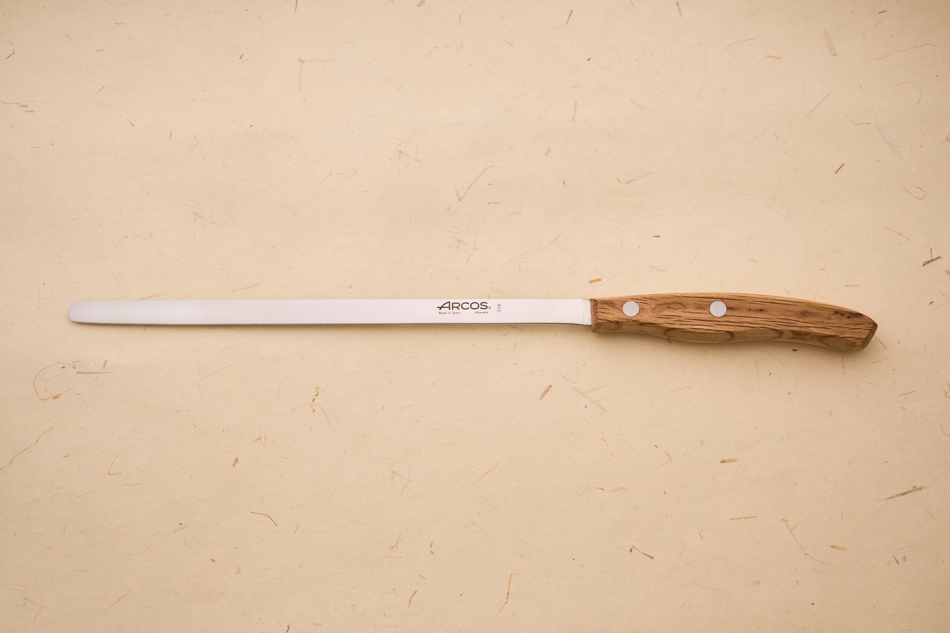Arcos Jose Andres Ham Knife with a slim steel blade and wooden handle, reflecting the brand's centuries-old Spanish blade craftsmanship.