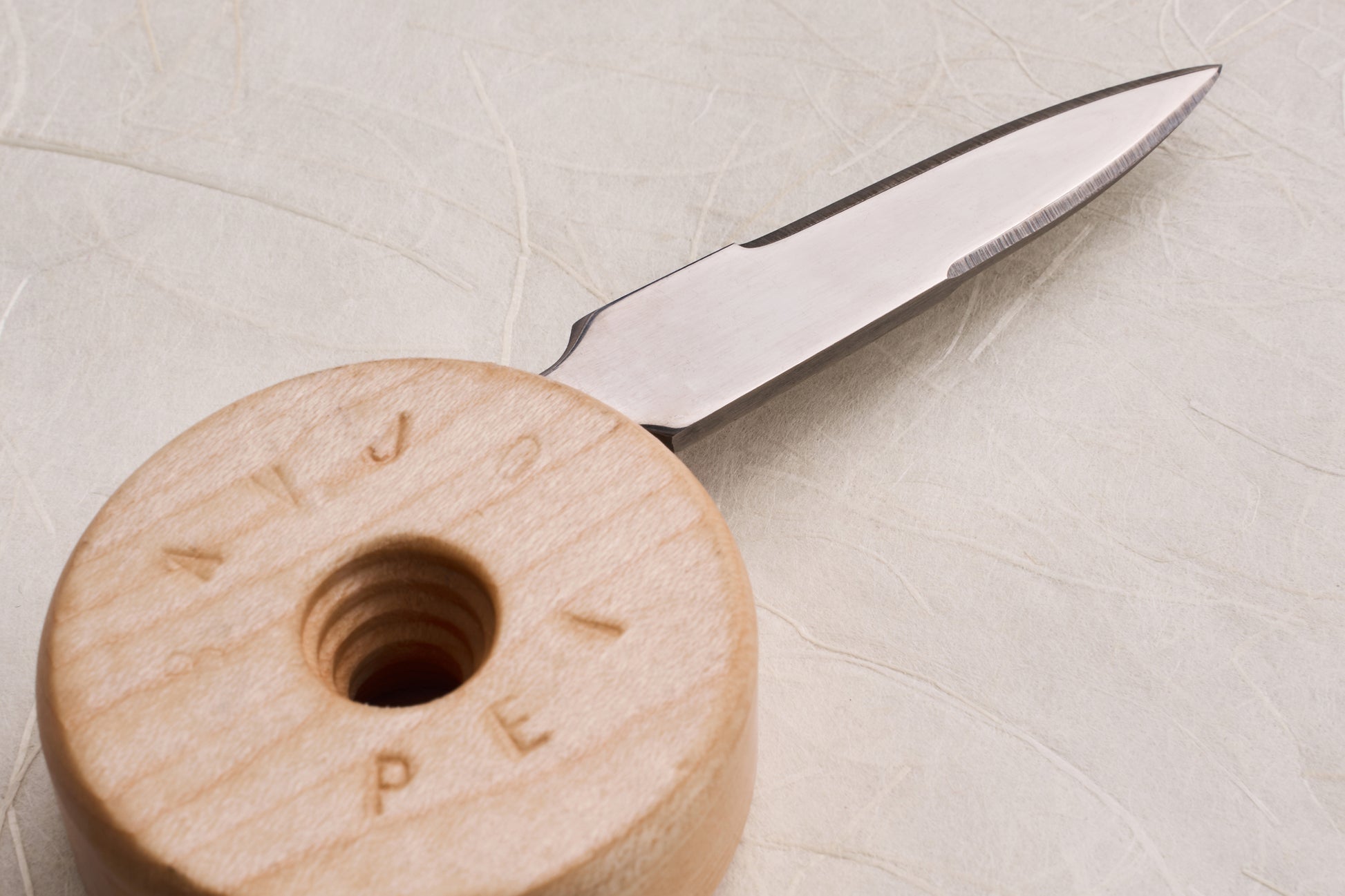 Banjo Oyster Knife with a wooden spool handle concealing a small metal blade, designed for ergonomic shucking with a 2.5 precision stainless steel blade.