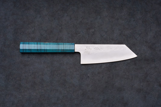 Blue Handle Hado Shiosai Ko-Bunka 135mm knife with a hammered stainless blade and turquoise octagonal handle, displayed on a dark slate surface.