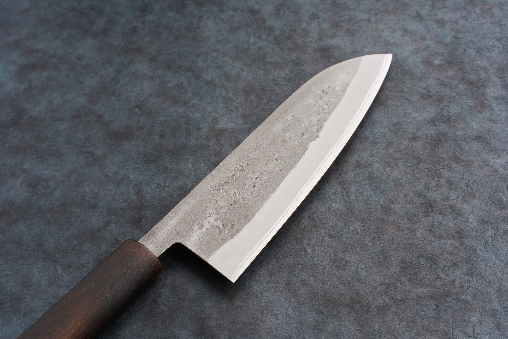 Fujimoto Nashiji Santoku 165mm knife with a wide, gently curved blade featuring a hammered finish and polished edge, paired with a dark wood octagonal handle, ideal for versatile kitchen tasks.