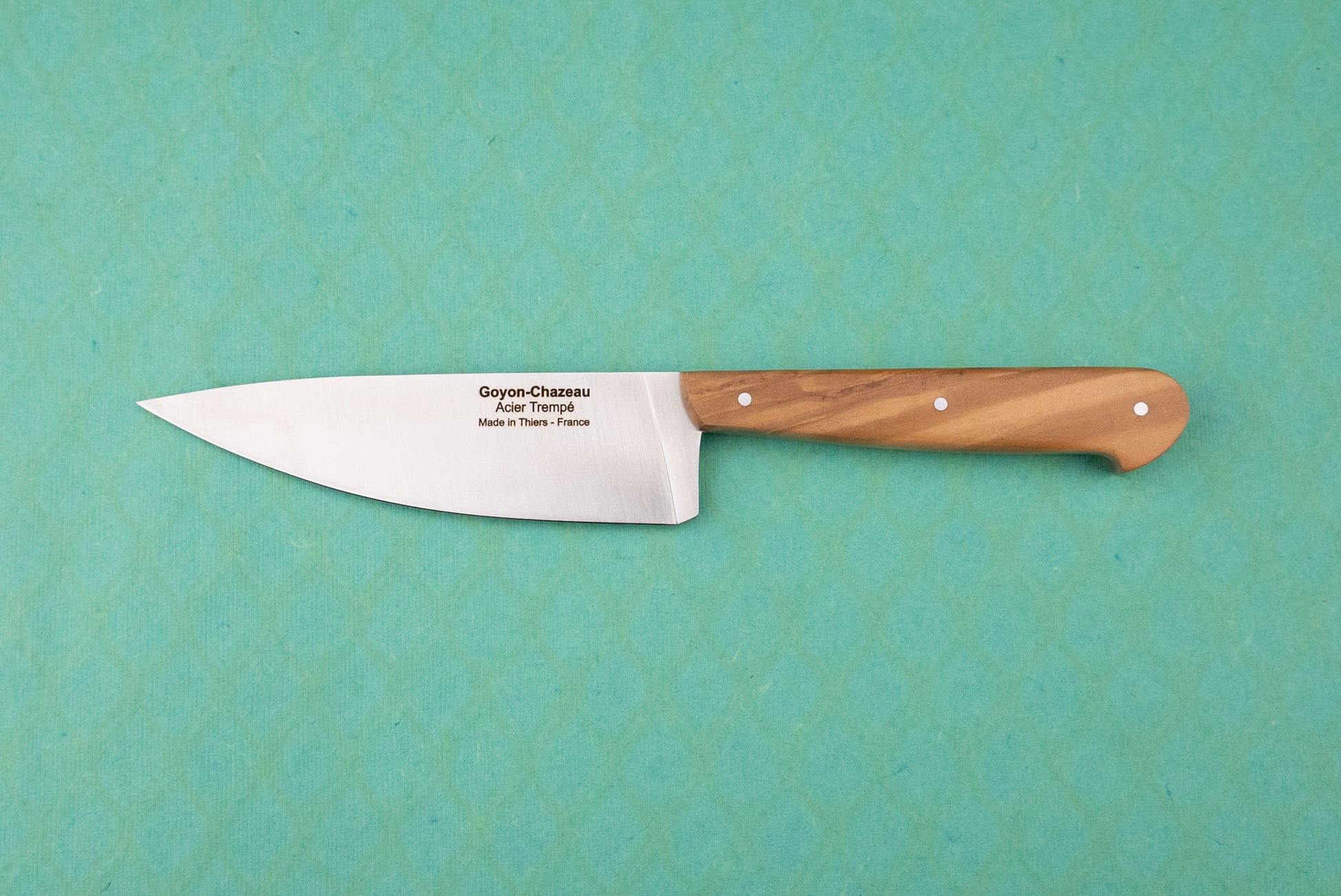 Goyon-Chazeau Le Grand Tradi chef's knife, featuring a long stainless-steel blade with engraved details, and a smooth, riveted wooden handle, designed for precision in smaller kitchen tasks.