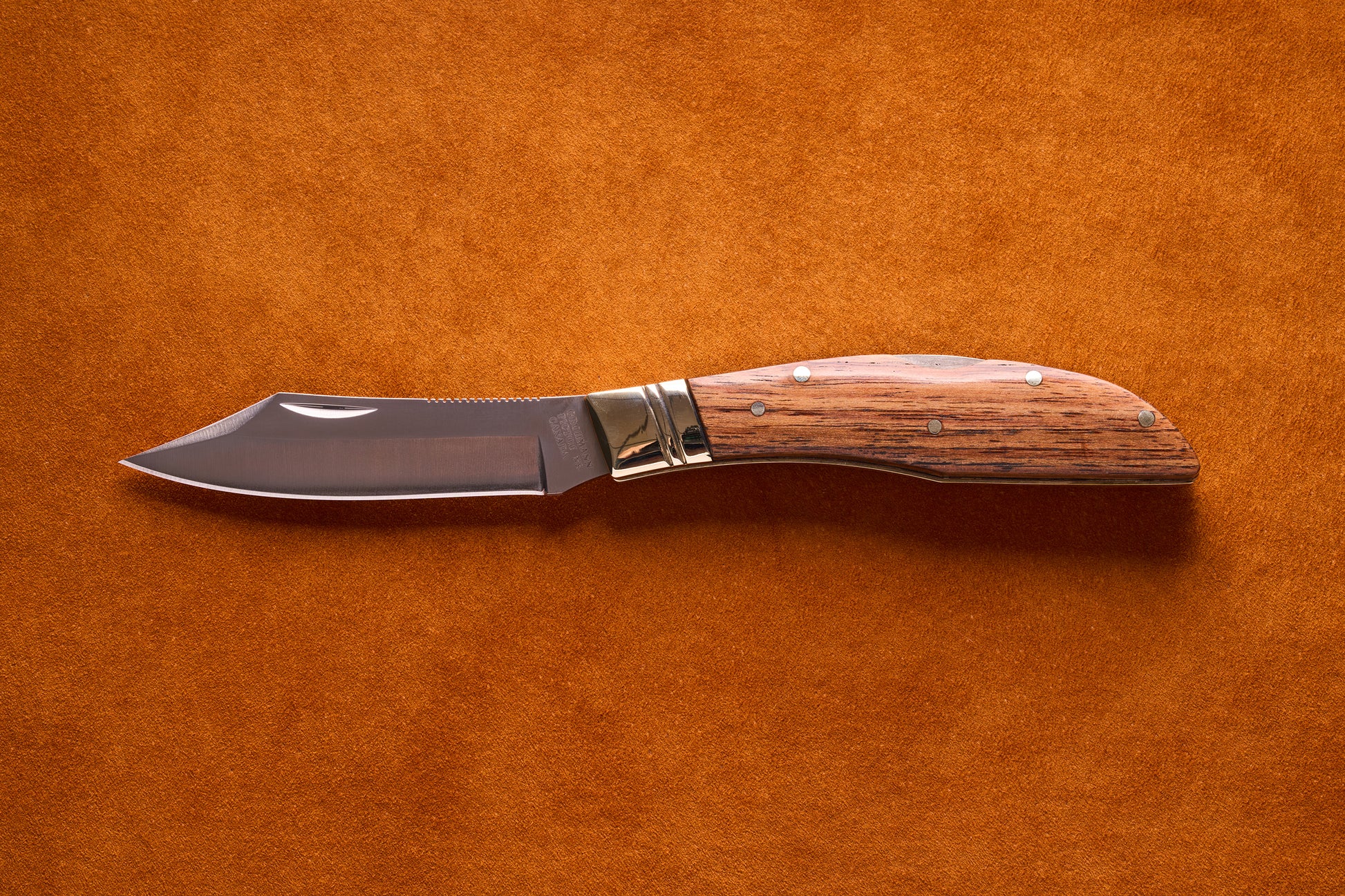 Grohmann Mini Russell Lockblade with Rosewood Handle, featuring a 4 stainless steel clip point blade, displayed open on a suede surface.