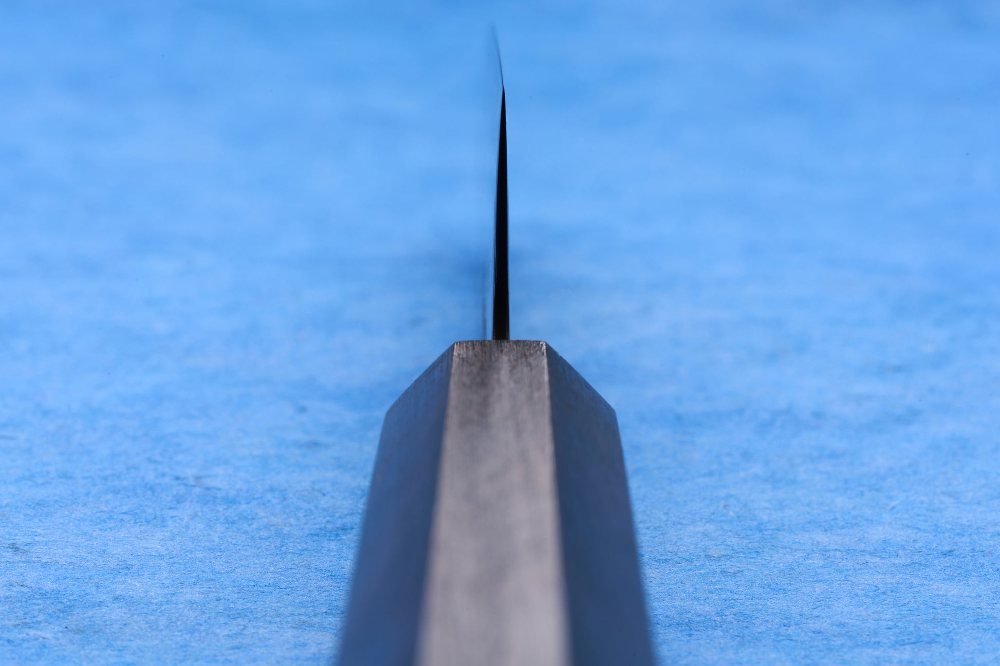 Hatsukokoro SLD Hikari Kurozome Damascus Santoku 170mm, viewed end-on, showcasing its precise, sharp edge and elegant steel shank, ideal for versatile kitchen tasks.