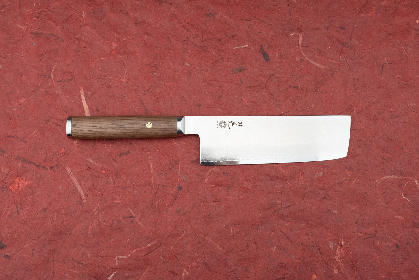 Hazaki Pro Series Nakiri 165mm features a straight, rectangular blade with Japanese engravings and a hammered pattern, paired with a dark wood handle and decorative brass mosaic pin.