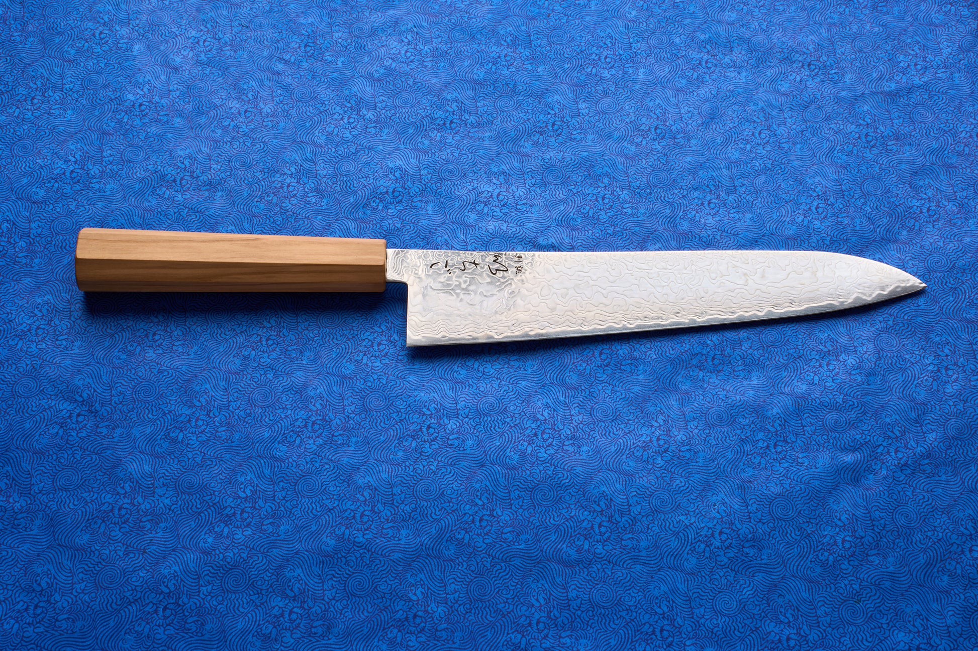 ICHIGO Haku Gyuto 240mm, a Japanese chef's knife, features a high-carbon Damascus-patterned blade and a light wooden octagonal handle, ideal for versatile kitchen tasks like slicing and dicing.