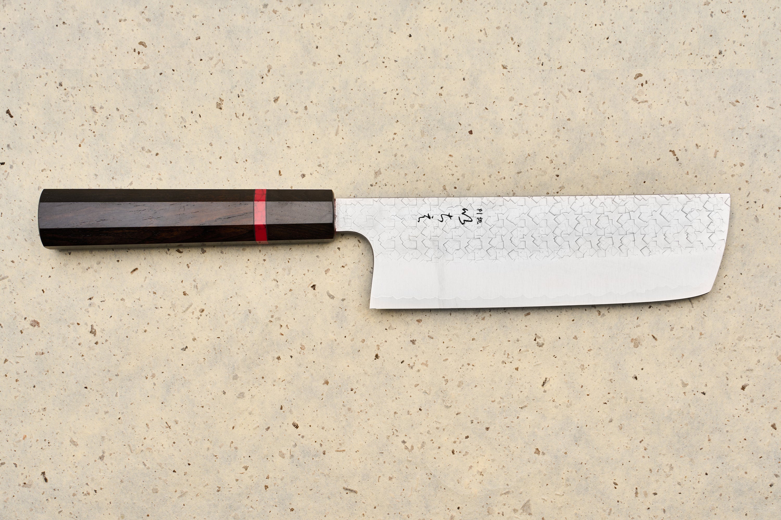 ICHIE x Shibata Knives SG2 Tsuchime Nakiri 165mm features a straight, rectangular Damascus blade with Japanese characters, complemented by an octagonal dark wood handle with a red accent ring, ideal for precise vegetable chopping.
