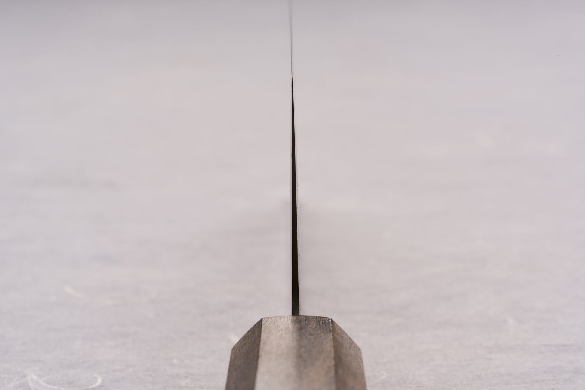 Edge-on view of the ICHIGO SLD Migaki Nakiri 160mm, showcasing its ultra-thin blade and dark wooden handle, ideal for effortless vegetable chopping with Japanese precision and craftsmanship.