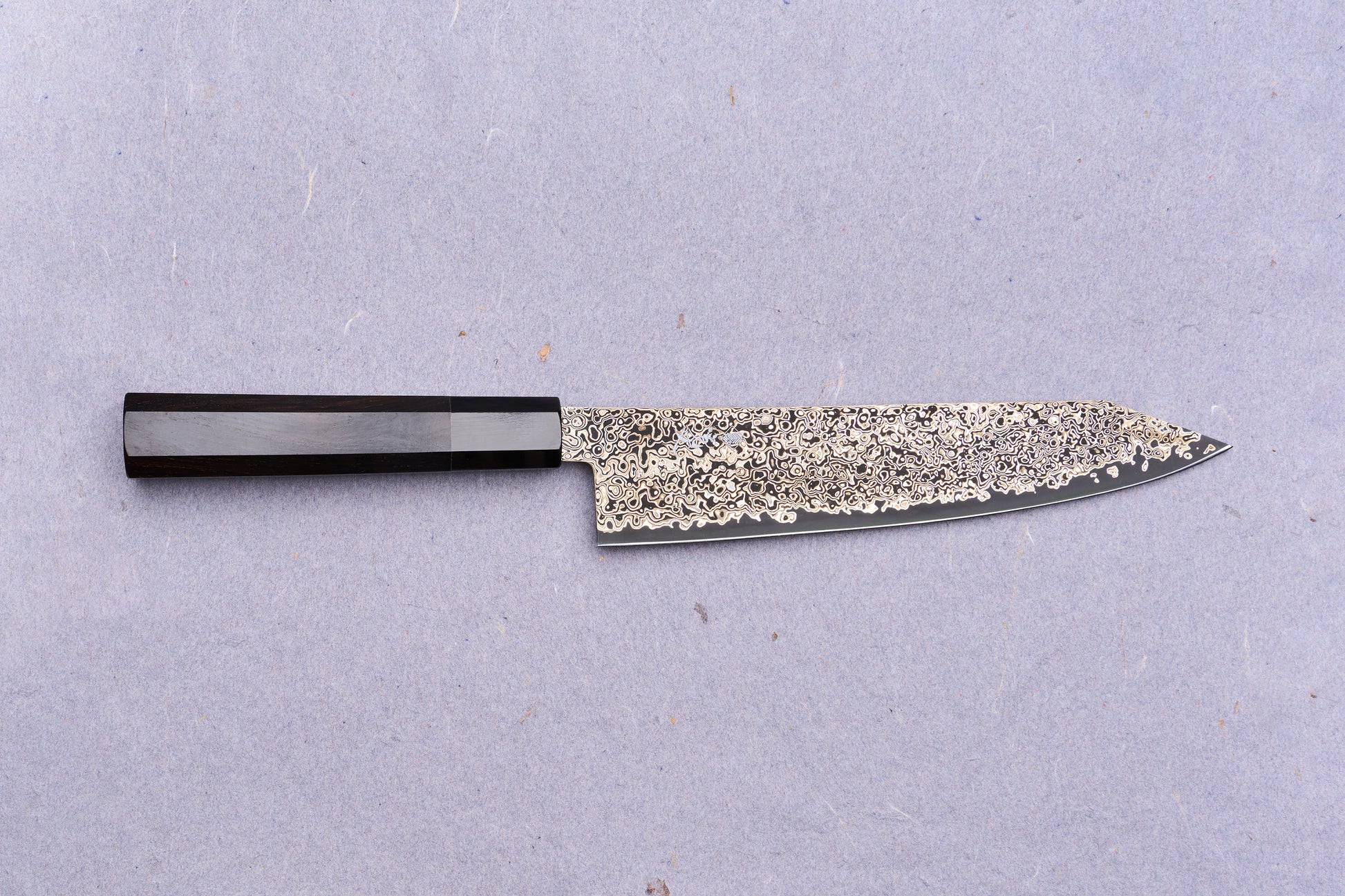 Kanjo SG2 Nickel Damascus Kiritsuke Gyuto 210mm: A Japanese chef's knife featuring a patterned Damascus blade and dark octagonal wooden handle, ideal for versatile kitchen tasks.