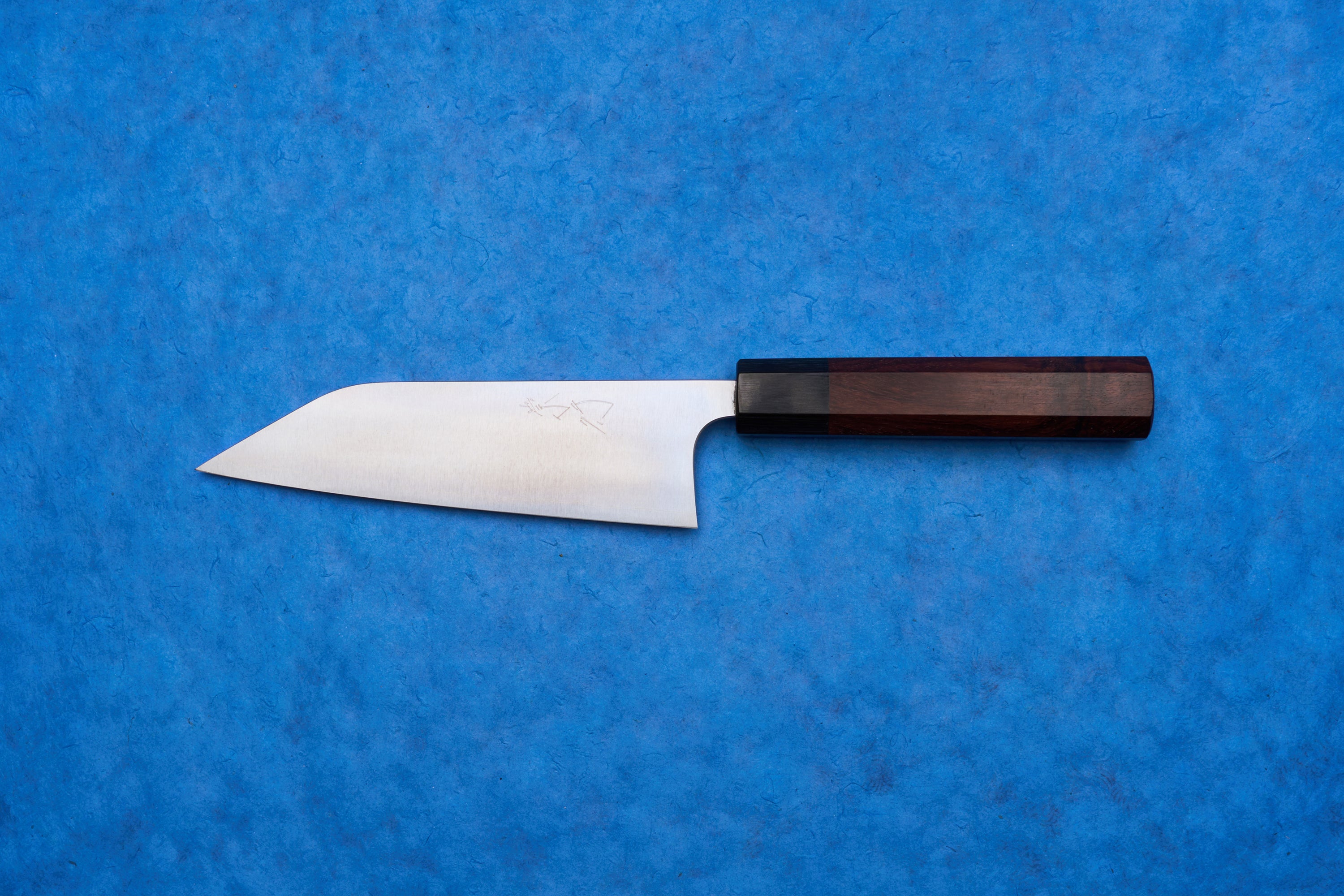 Shibata Koutetsu Chromax Migaki Santoku 165mm knife with a stainless-steel blade and octagonal wooden handle, ideal for slicing, dicing, and mincing, captures Japanese craftsmanship for versatile kitchen use.