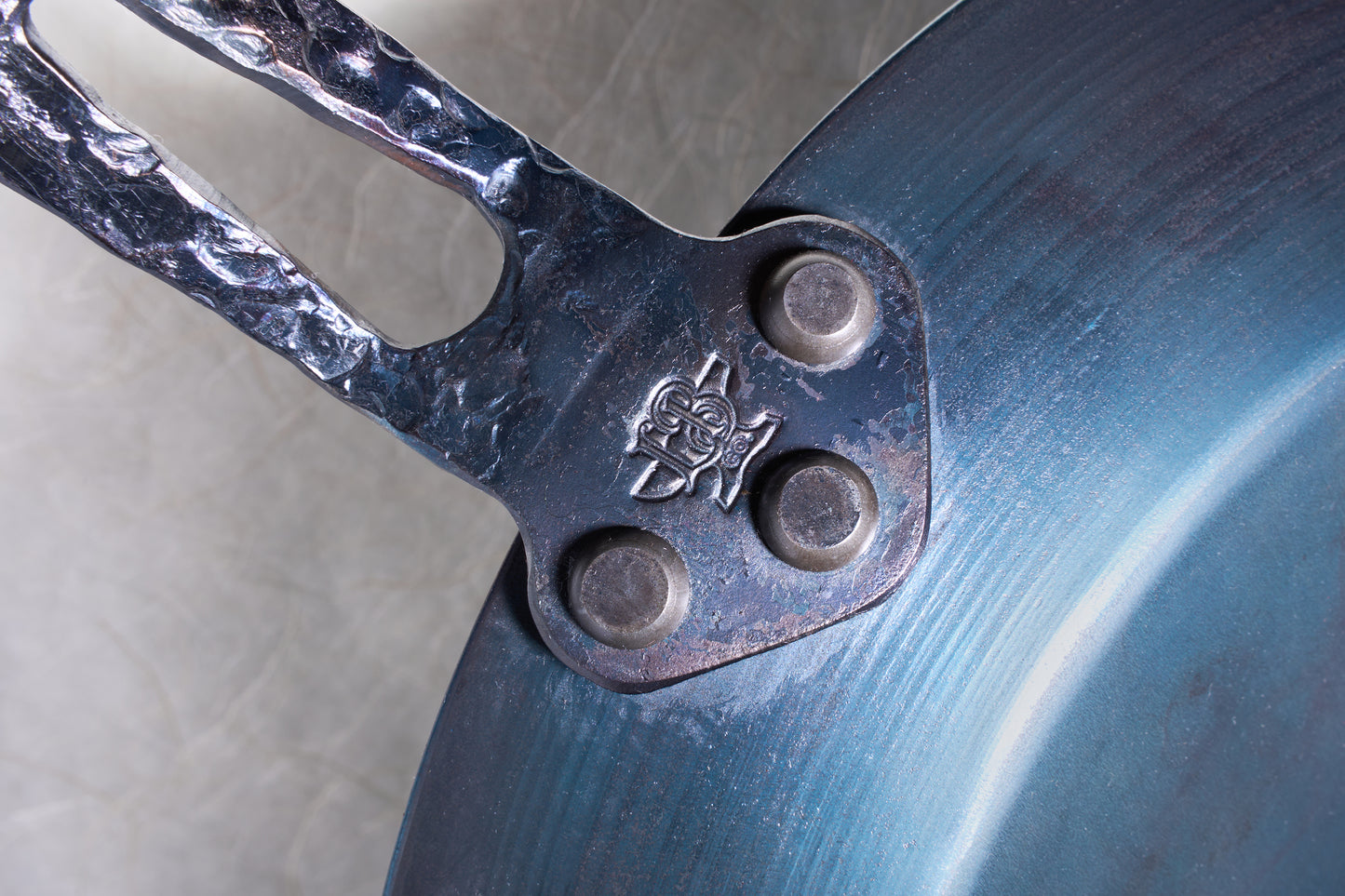 Leechtown Blacksmith Co. Medium Flamerider Carbon Steel pan with riveted, hammered handle and maker’s mark, showcasing craftsmanship ideal for versatile, long-lasting kitchen use.