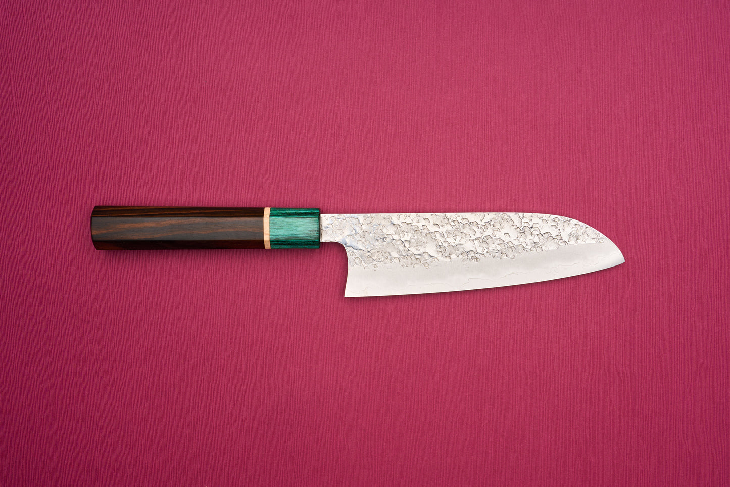 Makoto Kurosaki SPG STRIX Samidorizuki Santoku 165mm knife with a hammered blade and octagonal dark wood handle, featuring a greenish bolster, ideal for slicing, dicing, and mincing vegetables.