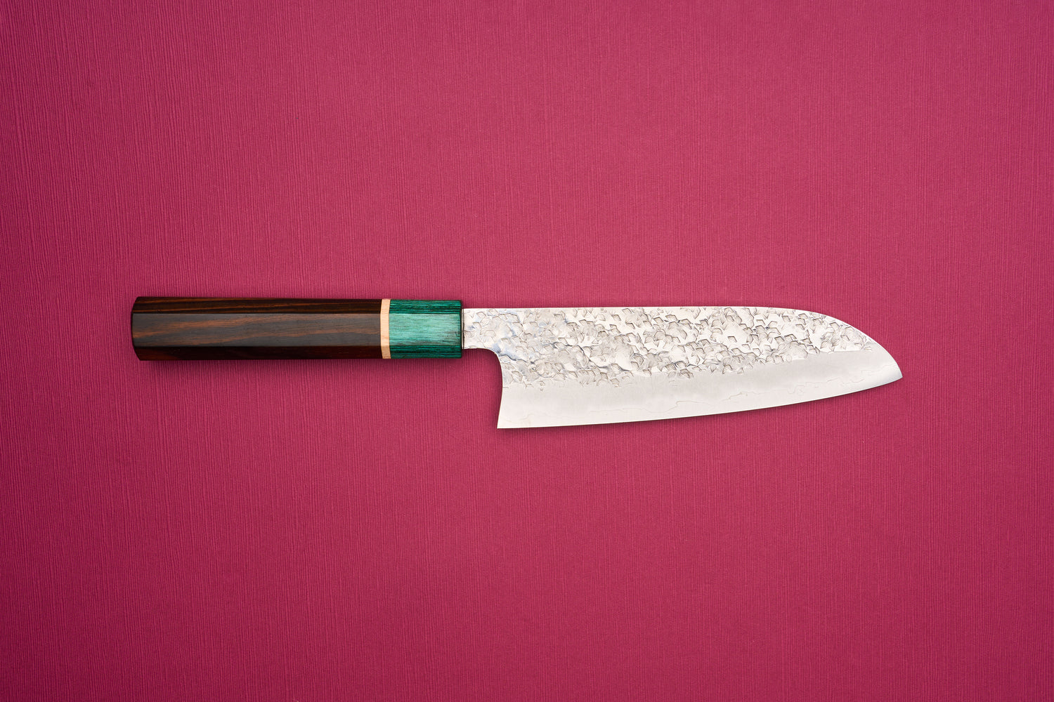 Makoto Kurosaki SPG STRIX Samidorizuki Santoku 165mm knife with a hammered blade and octagonal dark wood handle, featuring a greenish bolster, ideal for slicing, dicing, and mincing vegetables.