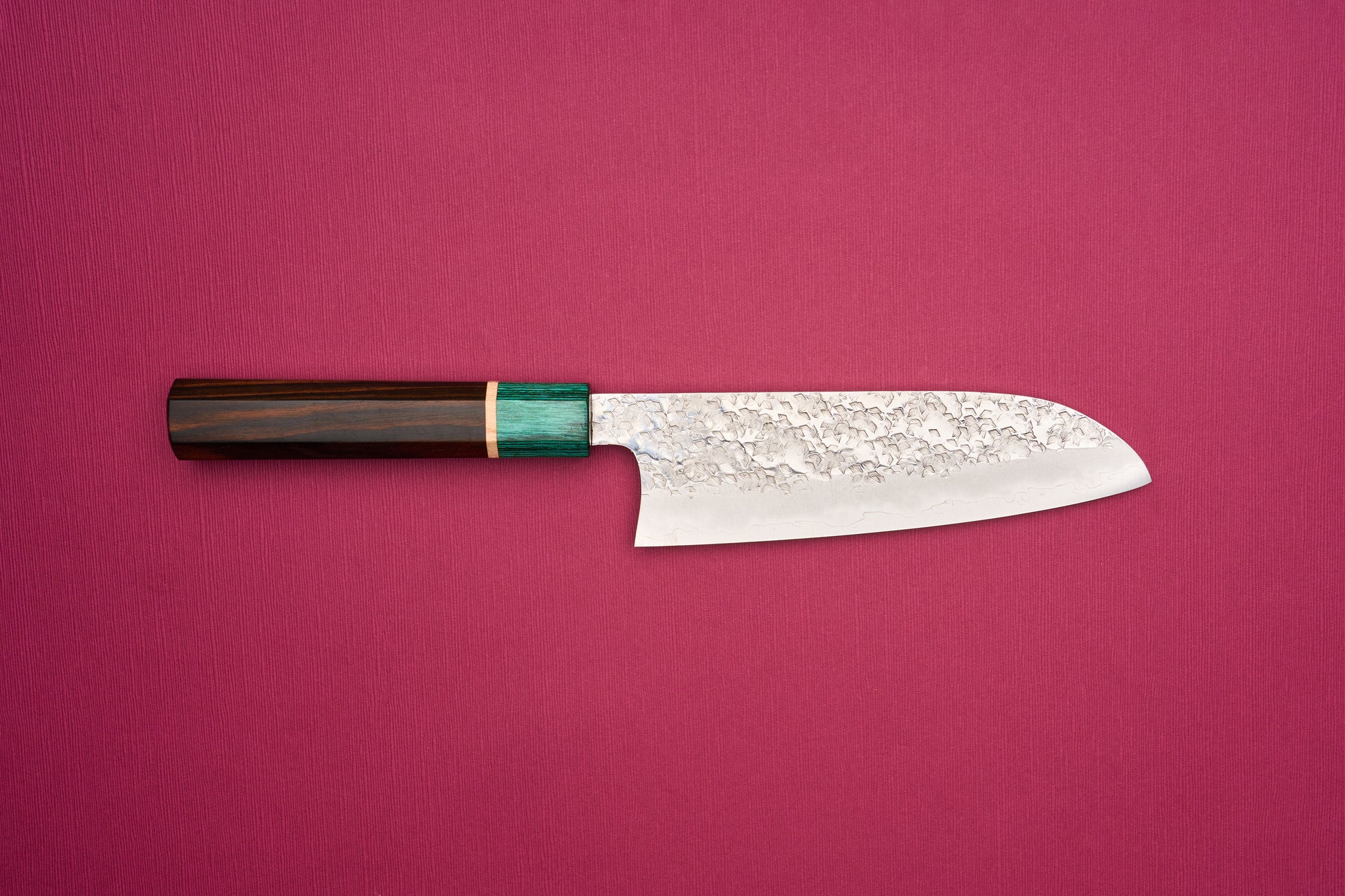 Makoto Kurosaki SPG STRIX Samidorizuki Santoku 165mm knife with a hammered blade and octagonal dark wood handle, featuring a greenish bolster, ideal for slicing, dicing, and mincing vegetables.