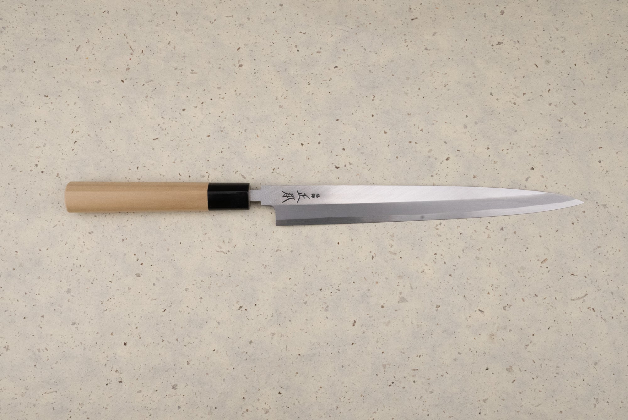 Masamoto KK Shirogami Kasumi Yanagiba 240mm knife with a polished single-bevel steel blade and etched Japanese characters, featuring an octagonal wooden handle, perfect for precise sashimi slicing.
