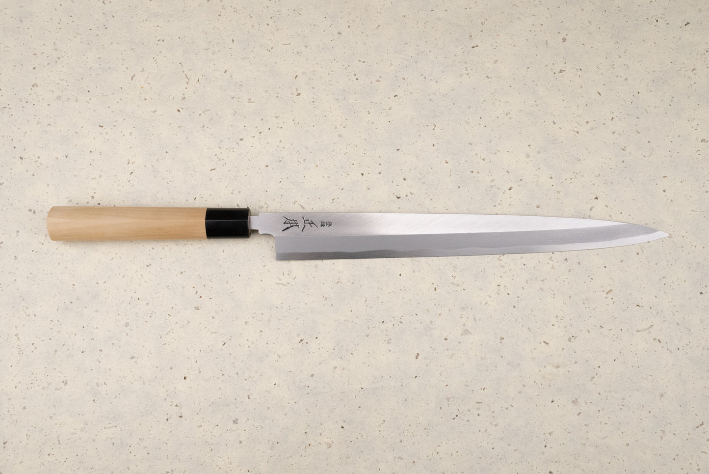 Masamoto KK Shirogami Kasumi Yanagiba 300mm knife with a single-bevel blade and Japanese characters, featuring an octagonal wooden handle with a black ferrule, perfect for slicing sashimi elegantly.
