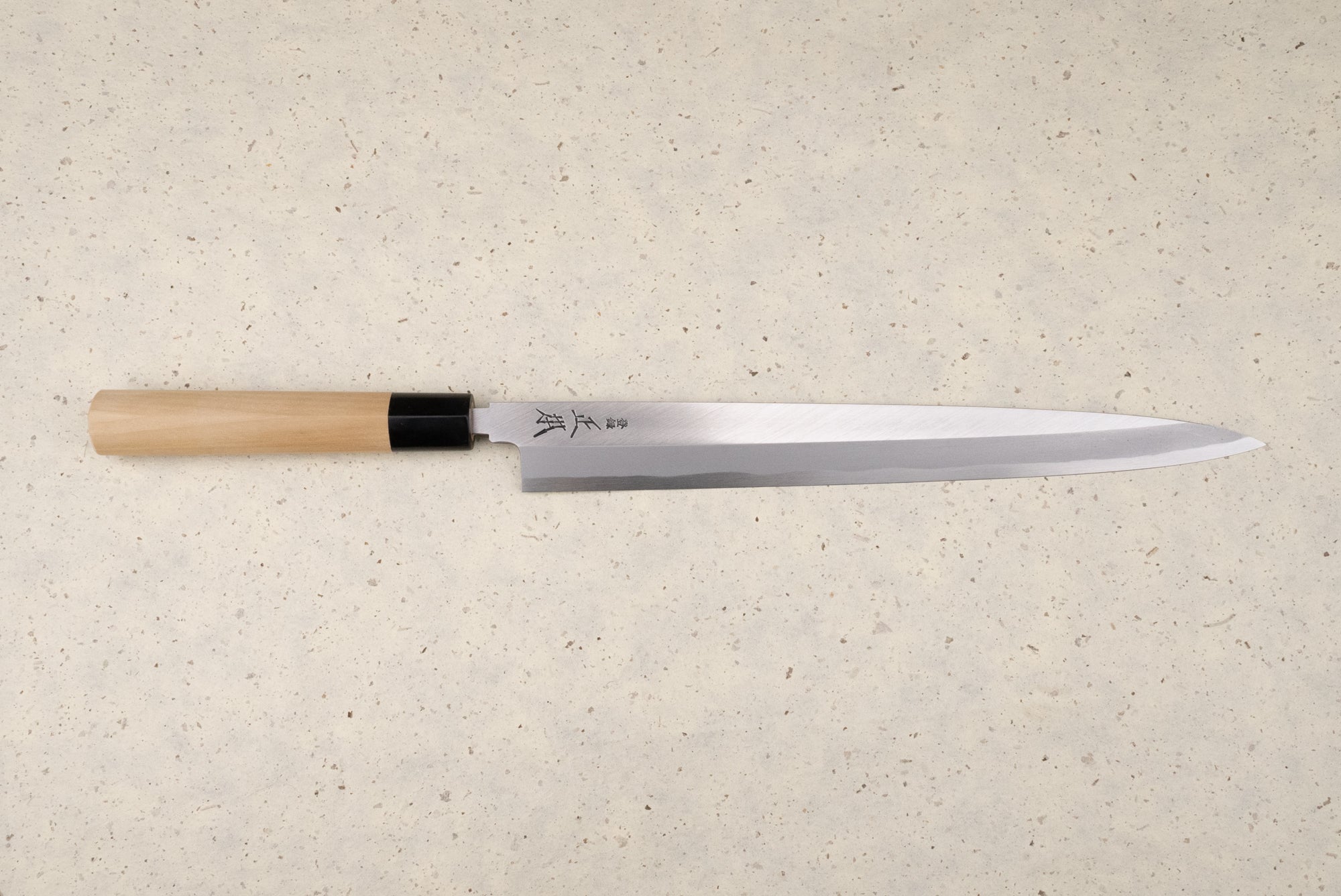 Masamoto KK Shirogami Kasumi Yanagiba 300mm knife with a single-bevel blade and Japanese characters, featuring an octagonal wooden handle with a black ferrule, perfect for slicing sashimi elegantly.
