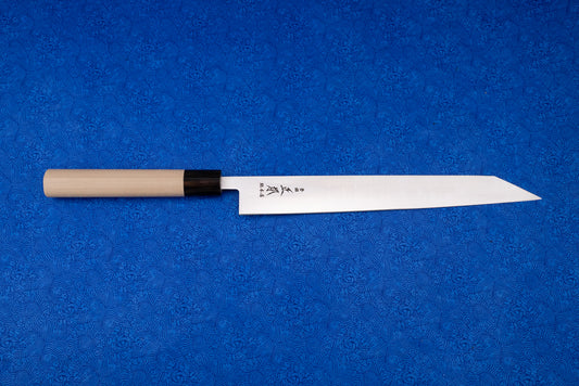 Masamoto MV Kensaki Sujihiki 255mm knife displayed on a blue patterned cloth, showcasing its sharp, narrow steel blade with Japanese etchings, black ferrule, and light wood handle, ideal for precise slicing.