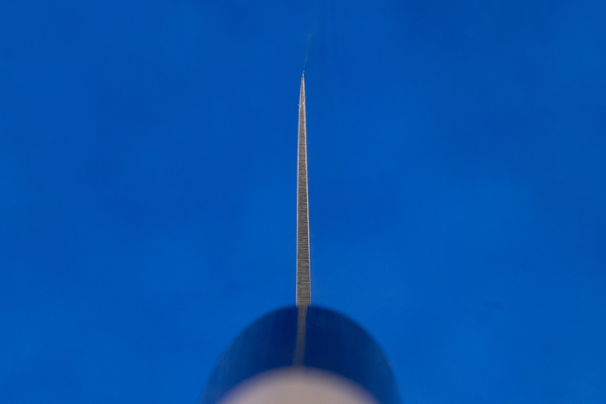 Masamoto MV Kensaki Sujihiki 255mm features prominently, showcasing its sharp, straight blade ideal for precision slicing. The knife's tip is centered, with the handle subtly out of focus below.
