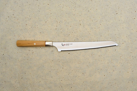 Mcusta Zanmai Beyond Bread Knife 230mm, featuring a serrated blade with MCUSTA ZANMAI – Made in Japan stamp, octagonal Hinoki wood handle; ideal for precise bread slicing.