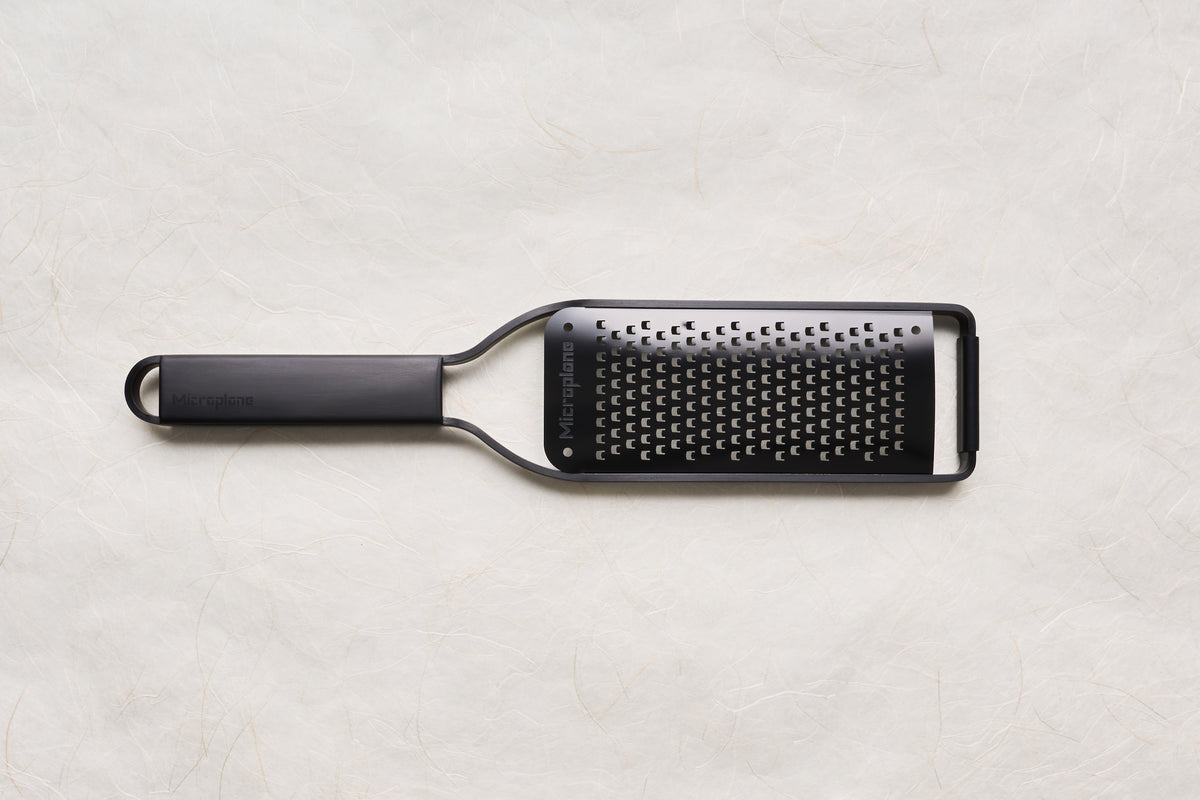 Microplane Black Sheep Series Grater with a sleek black handle and stainless steel blade, designed for zesting citrus and grating hard cheeses, embodying sharpness and precision ideal for culinary enthusiasts.