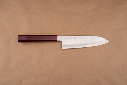 Naohito Myojin Cobalt Special Santoku 180mm showcased on a brown-kraft-paper background, featuring a polished steel blade with a subtle hamon line and a glossy, deep-red octagonal handle.