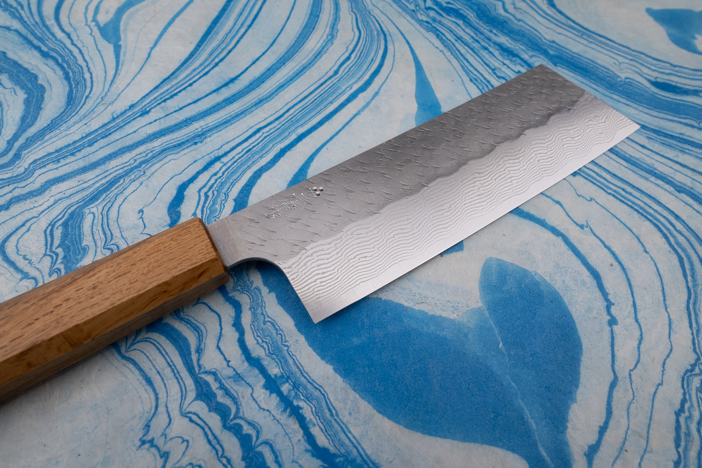 Nigara SPG STRIX Tsuchime Damascus Nakiri 180mm features a straight, rectangular blade with a hammered Damascus pattern and octagonal wooden handle, ideal for precise vegetable chopping in Japanese culinary style.