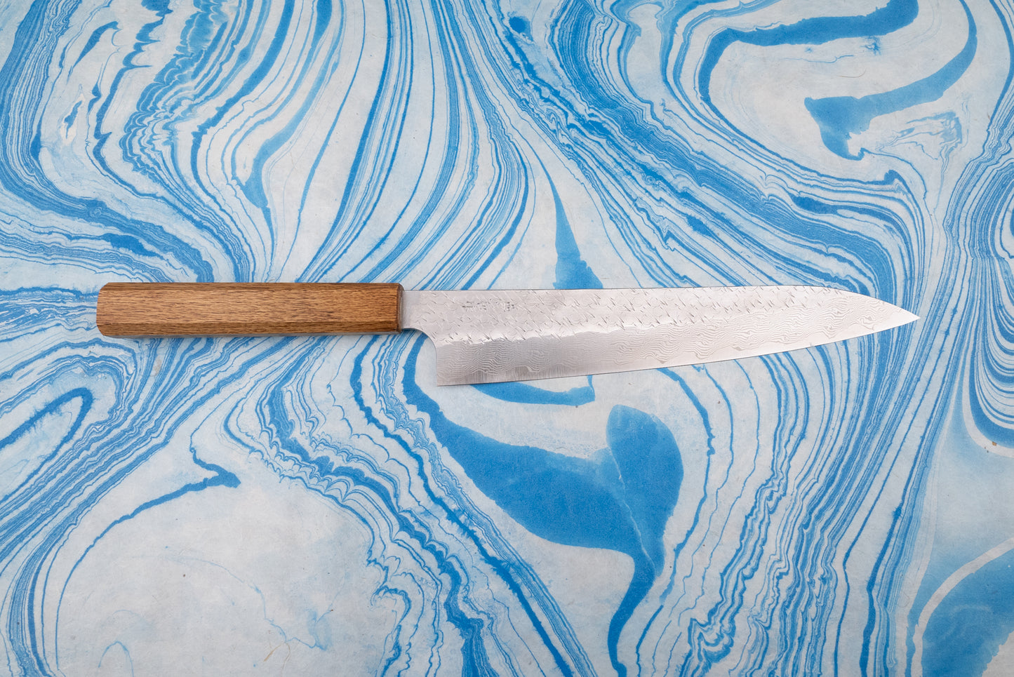 Nigara SPG STRIX Tsuchime Damascus Sujihiki 240mm, a Japanese-style chef's knife, features a narrow, etched Damascus blade and simple wooden handle, ideal for precise slicing tasks.