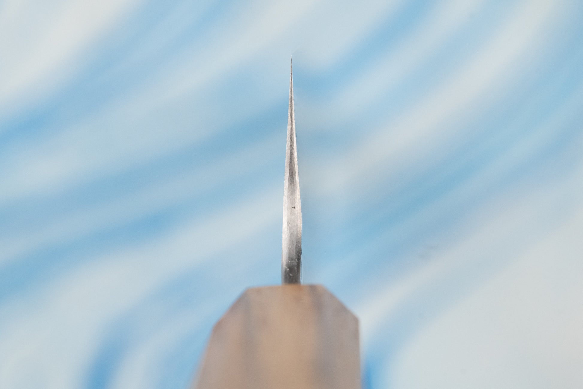 Nigara SPG STRIX Tsuchime Damascus Sujihiki 240mm—close-up of its slender, sharp blade with a wooden handle, showcasing expert craftsmanship ideal for precise slicing of meats and proteins.
