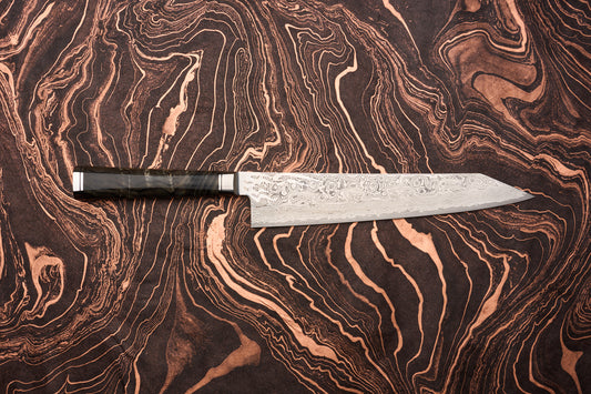 Ryusen Oukokuryu Gyuto 240mm knife features a distinctive Damascus steel blade with swirling patterns, set against a marbled black and copper background, showcasing its elegant design and craftsmanship.