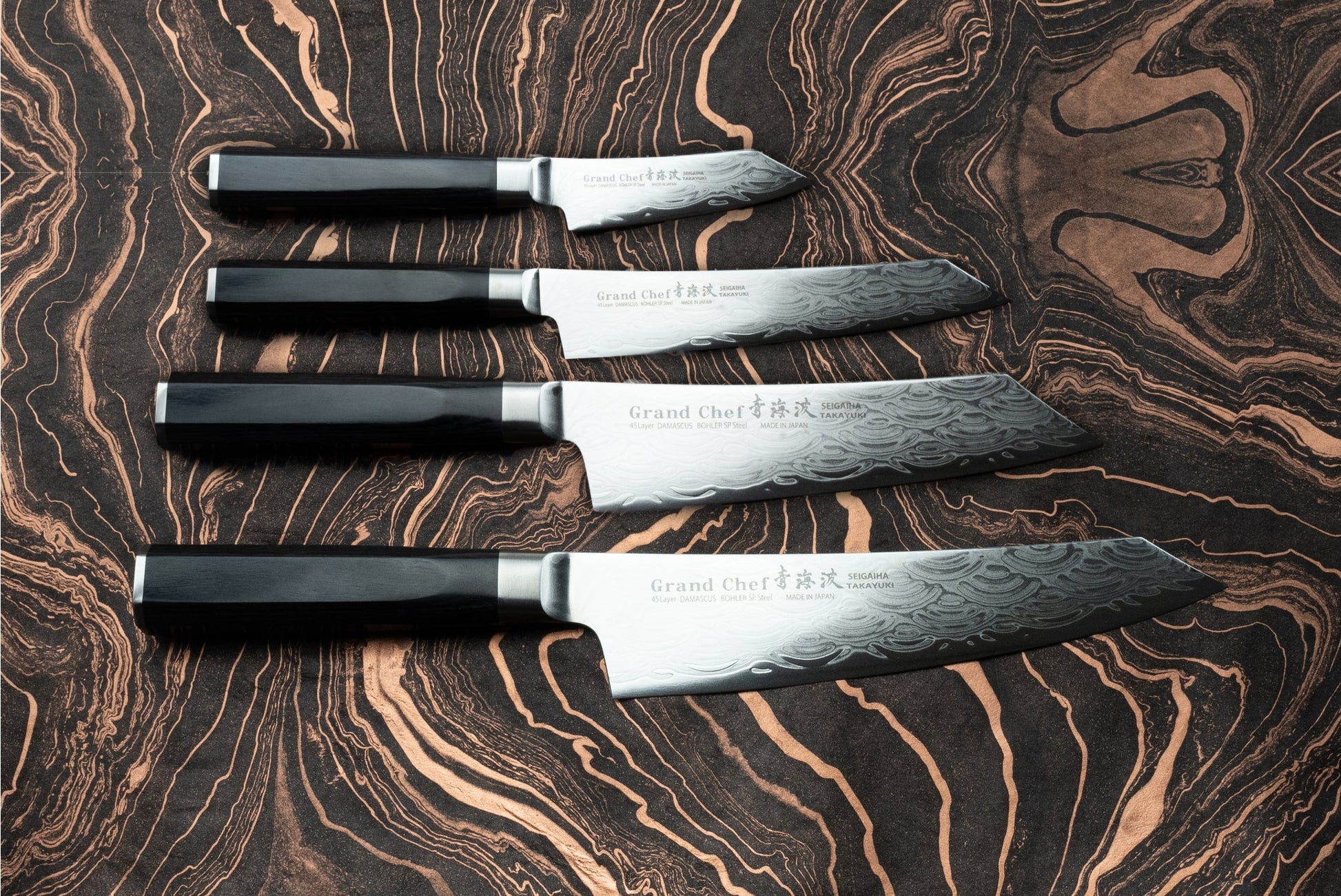 Sakai Takayuki Grand Chef Seigaiha 4 Piece Knife Set features Damascus-pattern blades with dark handles, expertly crafted for precision and sharpness, ideal for both home cooks and professional chefs.