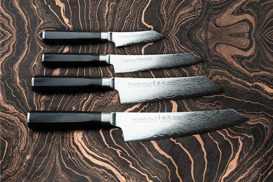 Sakai Takayuki Grand Chef Seigaiha 4 Piece Knife Set features Damascus-pattern blades with dark handles, expertly crafted for precision and sharpness, ideal for both home cooks and professional chefs.