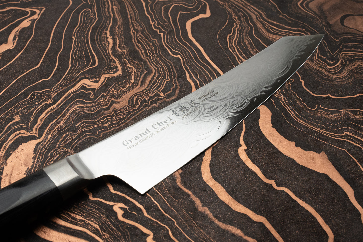 Sakai Takayuki Grand Chef Seigaiha Kengata Gyuto 190mm knife with a Damascus-patterned blade and kiritsuke tip, showcasing Grand Chef 45 Layer DAMASCUS Böhler SP Steel stamp and Japanese characters on a dark surface.