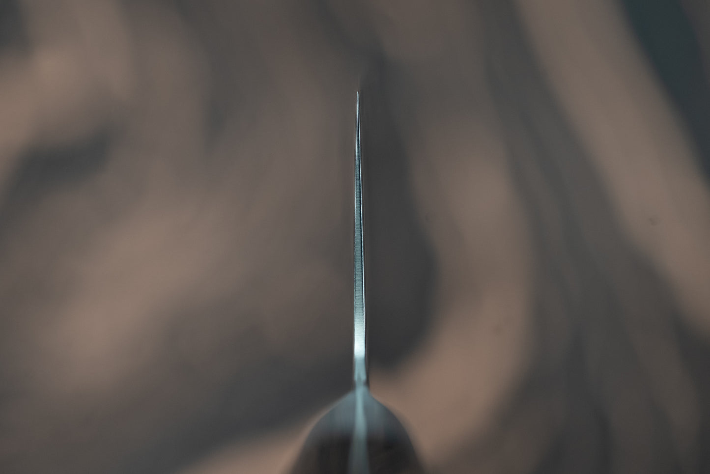 Close-up of the razor-thin edge of the Sakai Takayuki Grand Chef Seigaiha Kengata Gyuto 190mm, highlighting its sharpness and precision, crafted with Boehler Swedish steel and featuring a distinctive 'kiritsuke' tip.