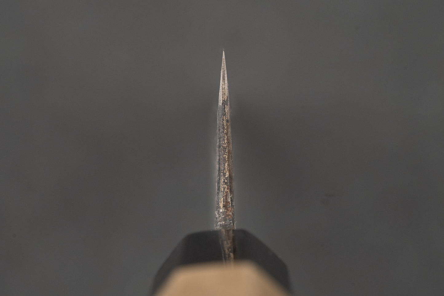 Shiro Kunimitsu Aogami Kurouchi Chikuzen Bunka 160mm blade close-up, showcasing its sharp, rustic bevels with surface rust, reflecting traditional Japanese craftsmanship from a renowned blacksmithing family.