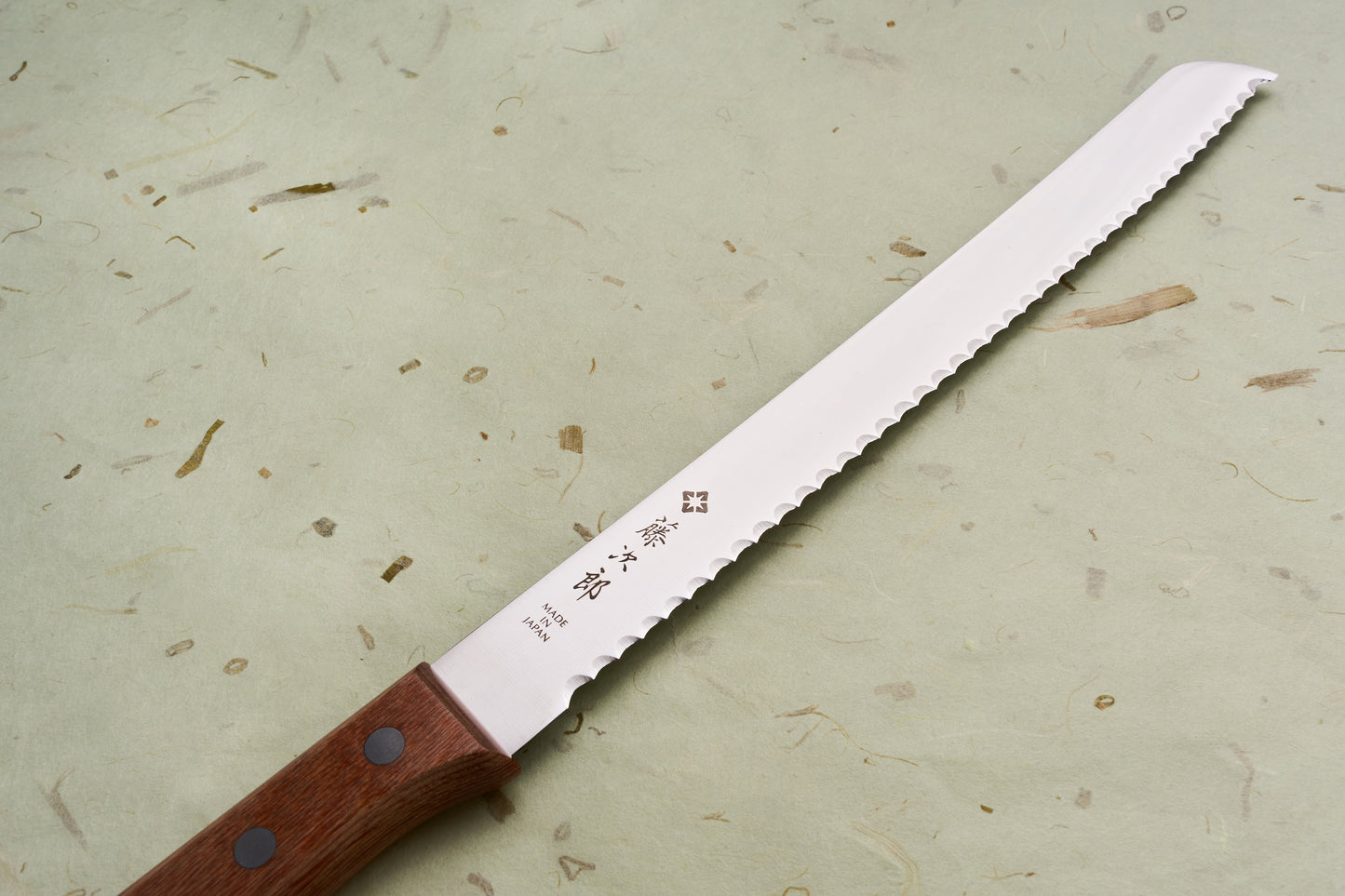TOJIRO Bread Slicer 235mm F-737, a serrated kitchen knife with a wooden handle, features Japanese characters on the blade, ideal for slicing bread effortlessly.