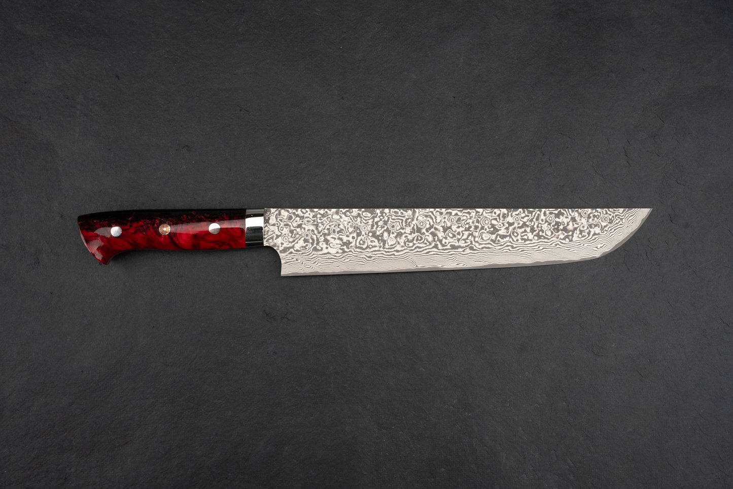 Takeshi Saji SG2 Black Damascus Western Sakimaru Sujihiki 240mm, featuring a Damascus steel blade with a hammered finish and deep-red handle, laid on a dark background, ideal for precise slicing.