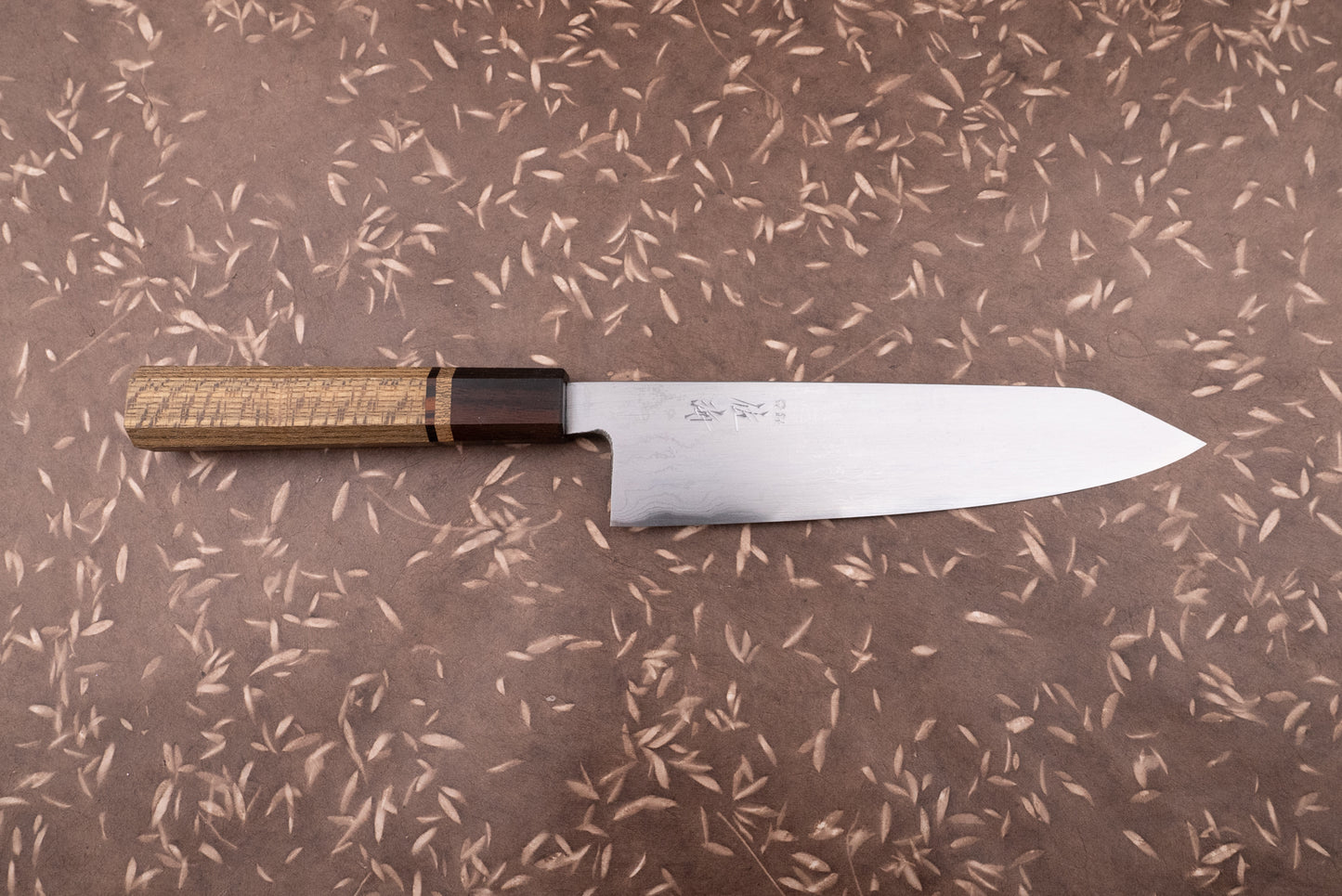 Touroku Sakai Aogami Damascus Kiritsuke Gyuto 210mm, featuring a stainless-steel blade with engraved kanji and an octagonal wooden handle, embodies masterful Japanese craftsmanship, ideal for culinary enthusiasts and professionals alike.