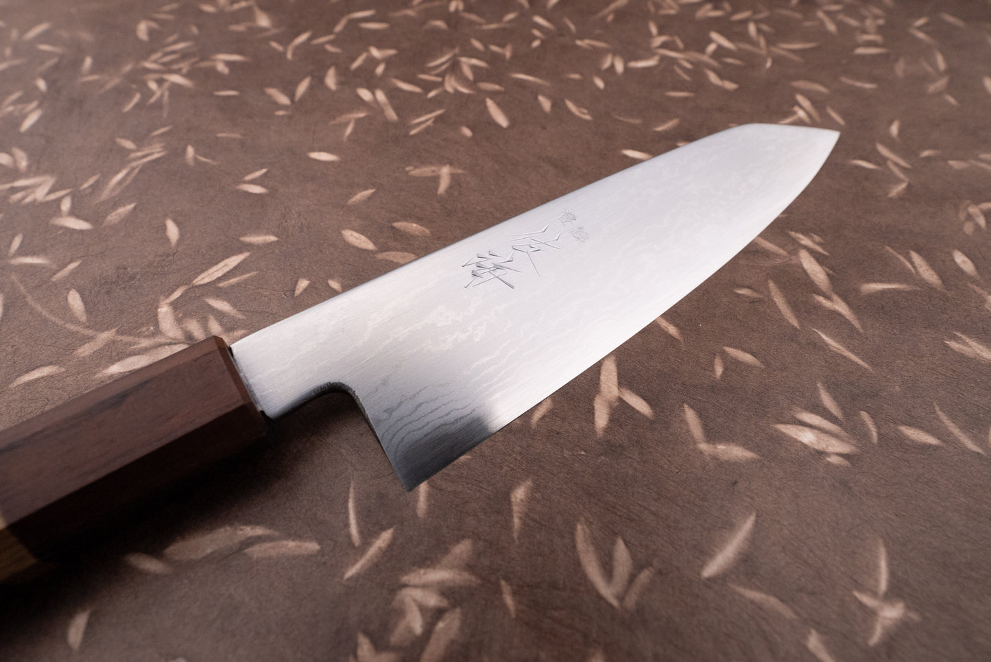 Touroku Sakai Aogami Damascus Kiritsuke Petty 150mm, a high-end Japanese kitchen knife, features a Damascus steel blade with a wavy pattern and Japanese characters, complemented by an octagonal wooden wa-handle.