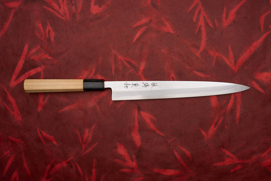 Touroku Sakai Shirogami Kasumi Yanagiba 240mm features a sleek, single-bevel blade and straight wooden handle. Perfect for sashimi slicing, it embodies precision and elegance, ideal for Japanese kitchen enthusiasts.